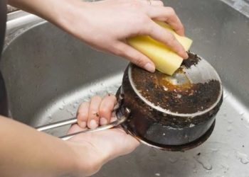 Dibi tutan tencereyi temizleyen tüyo. Tencere yanıkları yok oluyor